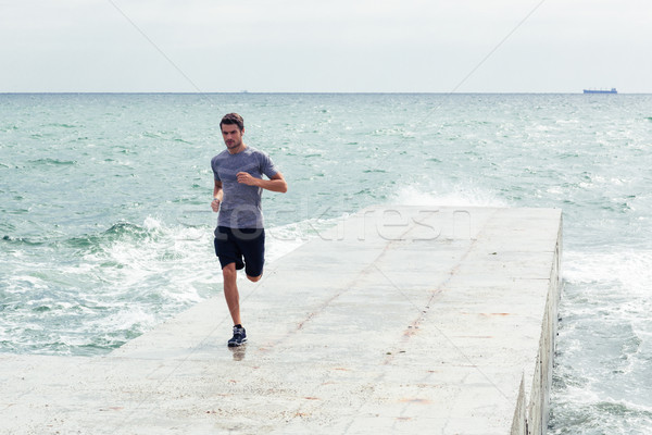 Man running at the beach outdoors Stock photo © deandrobot