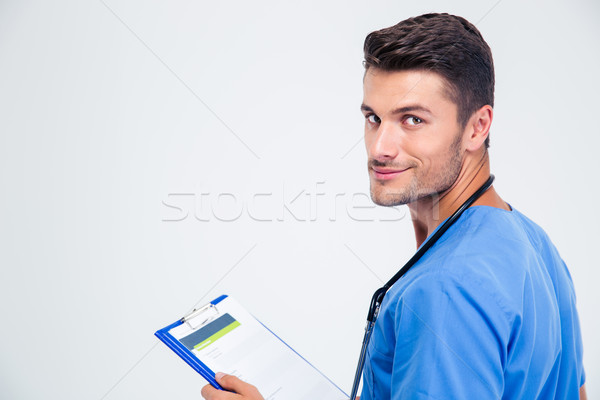 Portrait of a happy male doctor holding clipboard Stock photo © deandrobot
