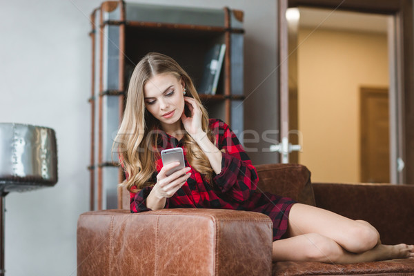 Thoughtful pretty girl in plaid shirt using cellphone  Stock photo © deandrobot