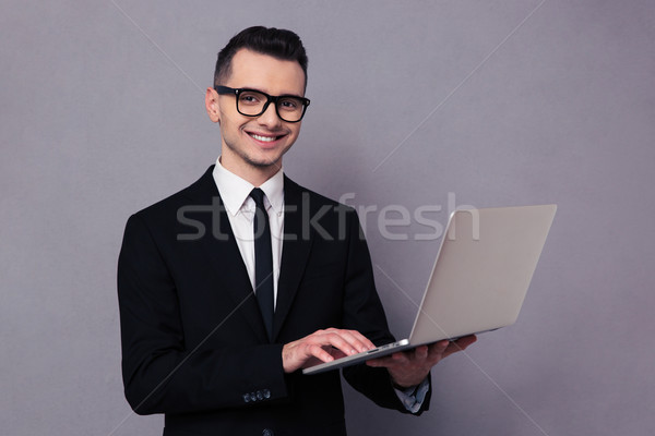 Stockfoto: Gelukkig · zakenman · met · behulp · van · laptop · computer · portret · grijs