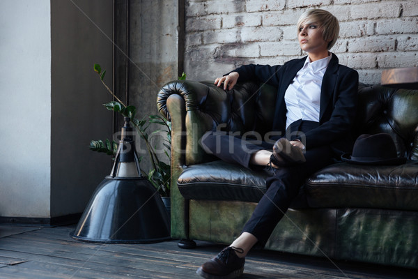 Stylish blonde girl sitting on the couch Stock photo © deandrobot