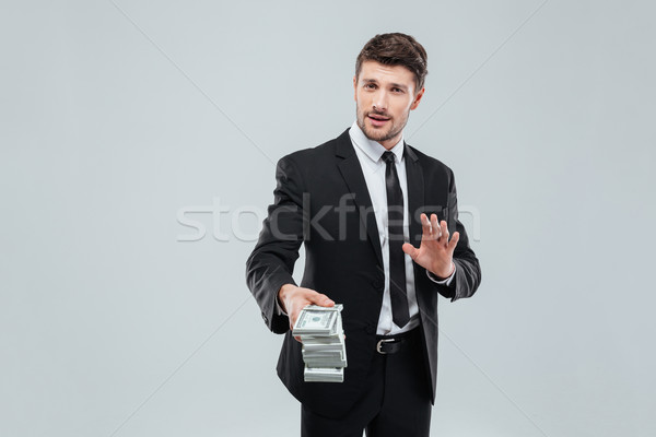 Attractive businessman in suit and tie giving you money back Stock photo © deandrobot
