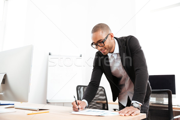 Businessman working watching statistics in a paper document Stock photo © deandrobot