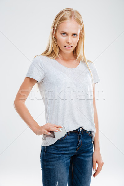 Beautiful young blonde girl putting smartphone in the jeans pocket Stock photo © deandrobot