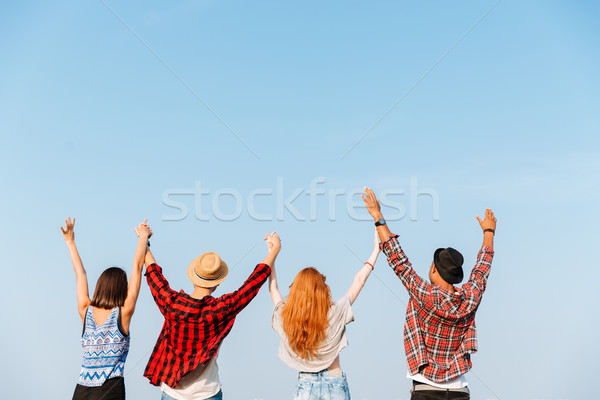 Achteraanzicht vier jongeren opgeheven handen groep Stockfoto © deandrobot
