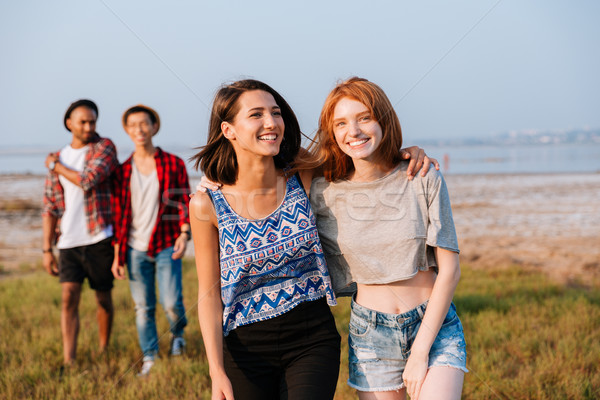 Two cheerful young men and women laughing outdoors Stock photo © deandrobot