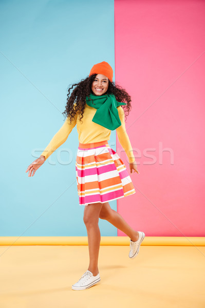 Full length of happy african young woman smiling and running Stock photo © deandrobot