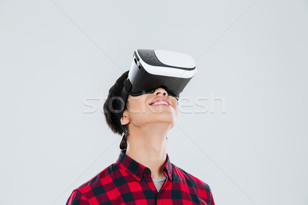 Cheerful asian man wearing virtual reality device Stock photo © deandrobot