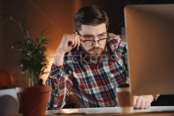 Concentrated bearded web designer working late at night Stock photo © deandrobot