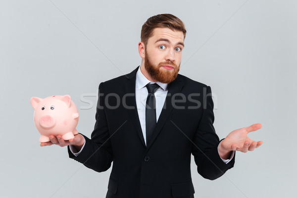 [[stock_photo]]: Homme · d'affaires · tirelire · étonné · costume · noir · livre