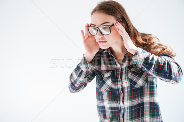 Portrait of beautiful woman in glasses standing and looking away Stock photo © deandrobot