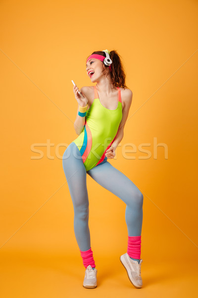 Woman athlete listening to music from cell phone and singing Stock photo © deandrobot
