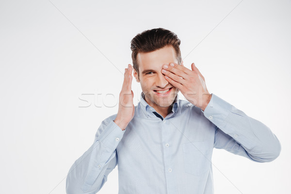 Smiling business man covering one eye Stock photo © deandrobot