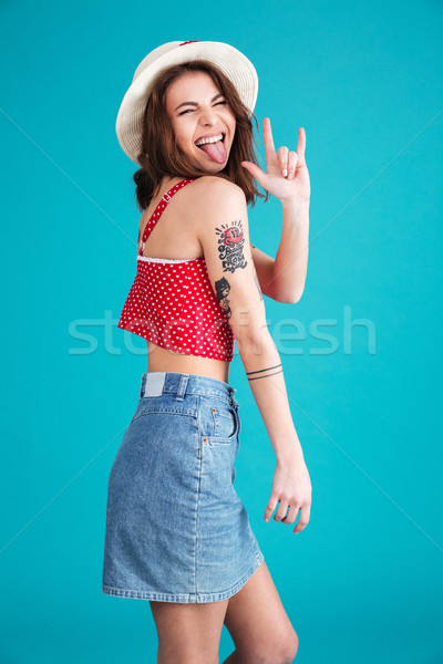 Funny naughty girl in hat showing rock sign with fingers Stock photo © deandrobot