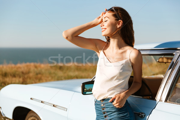 Smiling beautiful woman enjoying the sun while standing Stock photo © deandrobot