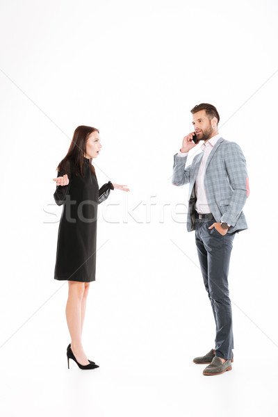 Angry woman looking at man talking by phone Stock photo © deandrobot