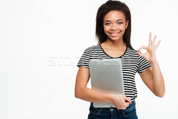 Portrait of a happy afro american teen girl holding laptop Stock photo © deandrobot