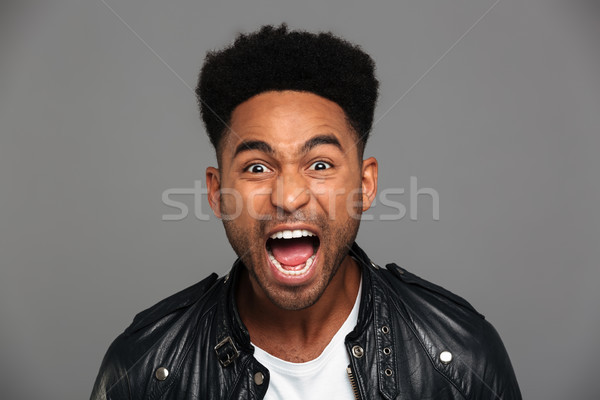 Portrait of a an angry african man with stubble Stock photo © deandrobot