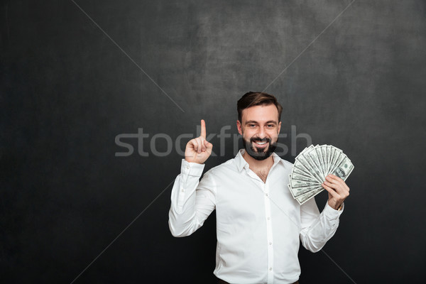 Portrait of lucky man in white shirt holding lots of money cash  Stock photo © deandrobot