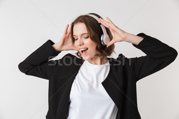 Emotional young woman standing isolated listening music Stock photo © deandrobot