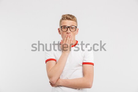 Photo of scared guy in eyeglasses looking at you and covering mo Stock photo © deandrobot