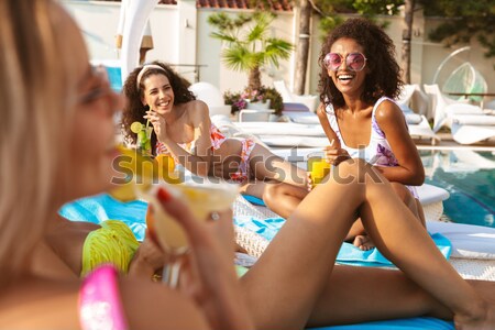 Back view image of four cheerful young women Stock photo © deandrobot