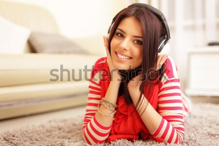 Smiling teen girl in colorful cloths lying on floor and relaxing Stock photo © deandrobot