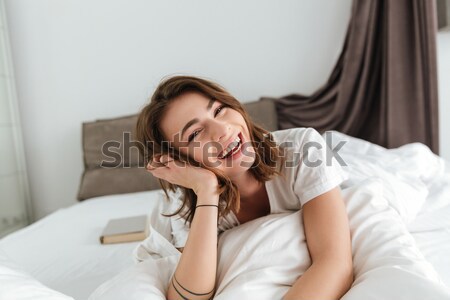 Happy smiling cute woman on the bed at home Stock photo © deandrobot