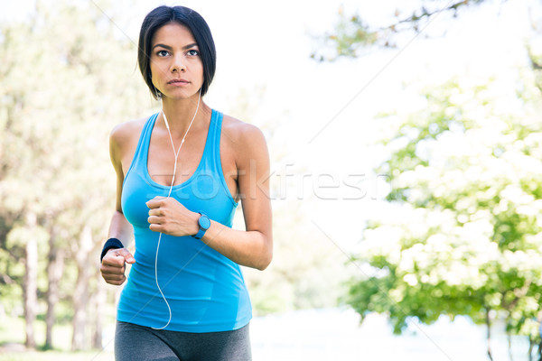 Sporty young woman running outdoors Stock photo © deandrobot