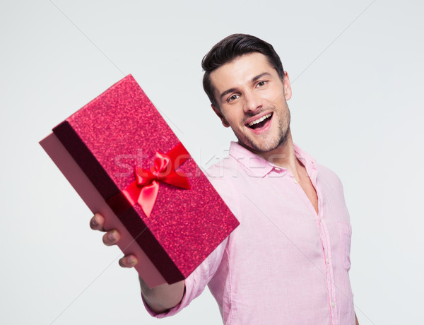 Businessman giving gift box at camera Stock photo © deandrobot