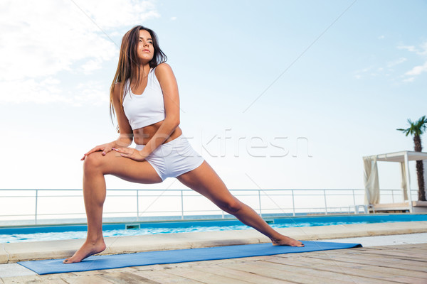 Stock photo: Girl doing stretching exercises outdoors