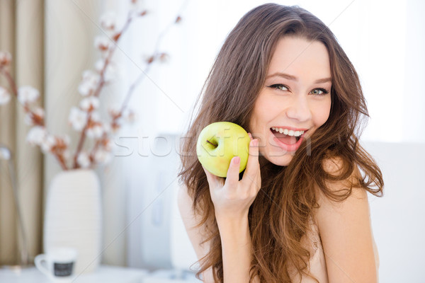 Beautiful happy woman holding apple at home Stock photo © deandrobot