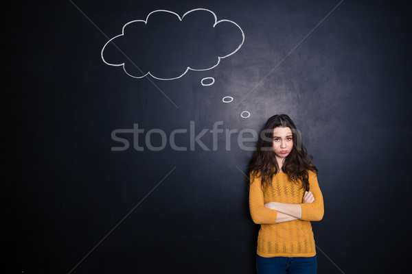 Sad woman standing with arms folded Stock photo © deandrobot