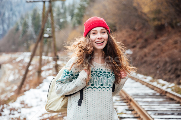 Smiling pretty young woman walking on railroad  Stock photo © deandrobot