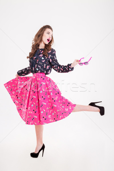 Happy charming young woman holding sunglasses and running away Stock photo © deandrobot