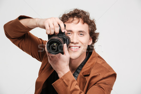 Smiling man photographing Stock photo © deandrobot