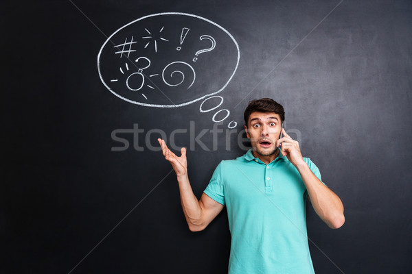 Meglepett megrémült férfi beszél mobiltelefon iskolatábla Stock fotó © deandrobot