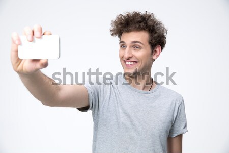 Cheerful young man using tablet and showing thumbs up Stock photo © deandrobot