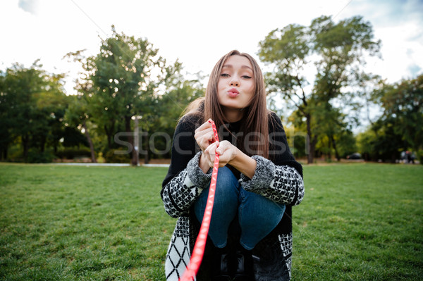 Happy woman sending a kiss to her dog on leash Stock photo © deandrobot