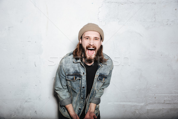Gritando barbudo homem posando parede Foto stock © deandrobot