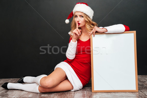 Woman in santa costume with white board showing silence sign Stock photo © deandrobot