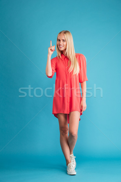 Happy inspired young woman pointing up and having an idea Stock photo © deandrobot