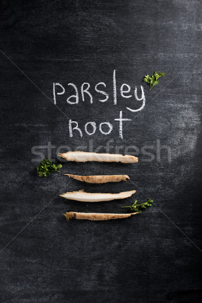 Photo of parsley root over dark chalkboard background. Stock photo © deandrobot