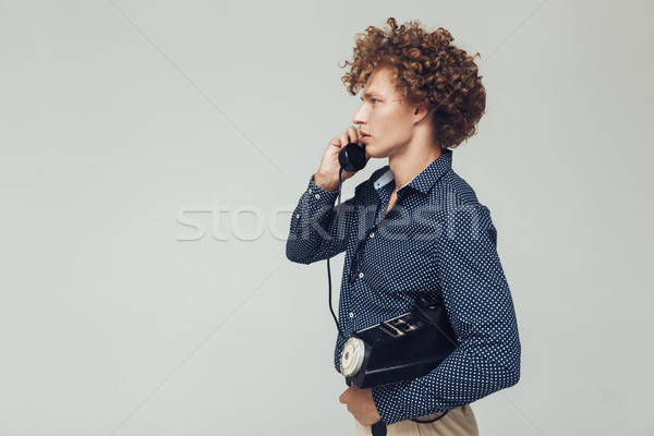 Handsome retro man with telephone in hands. Stock photo © deandrobot