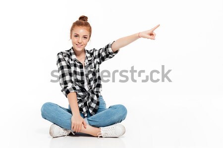Pleased ginger woman in shirt and jeans sitting on floor Stock photo © deandrobot