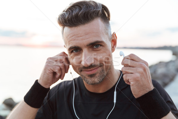 Close up portrait of a happy sportsman listening to music Stock photo © deandrobot