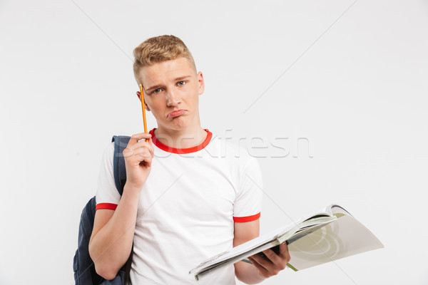 Image of young frustrated male student wearing backpack thinking Stock photo © deandrobot