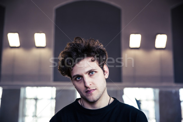 Portrait of a young serious man with curly hair Stock photo © deandrobot