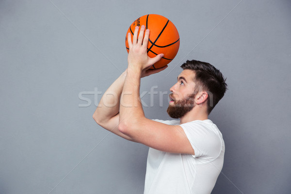 Young man reading to throw basket ball Stock photo © deandrobot