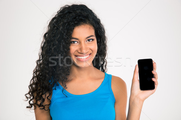 Stock photo: Smiling afro american woman showing blank smartphone screen